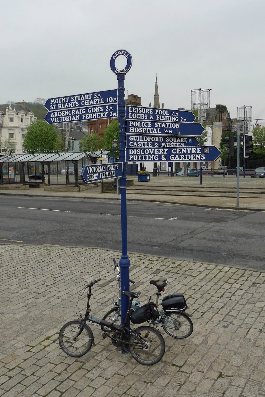 Rothesay waysign with two folding bikes parked beneath