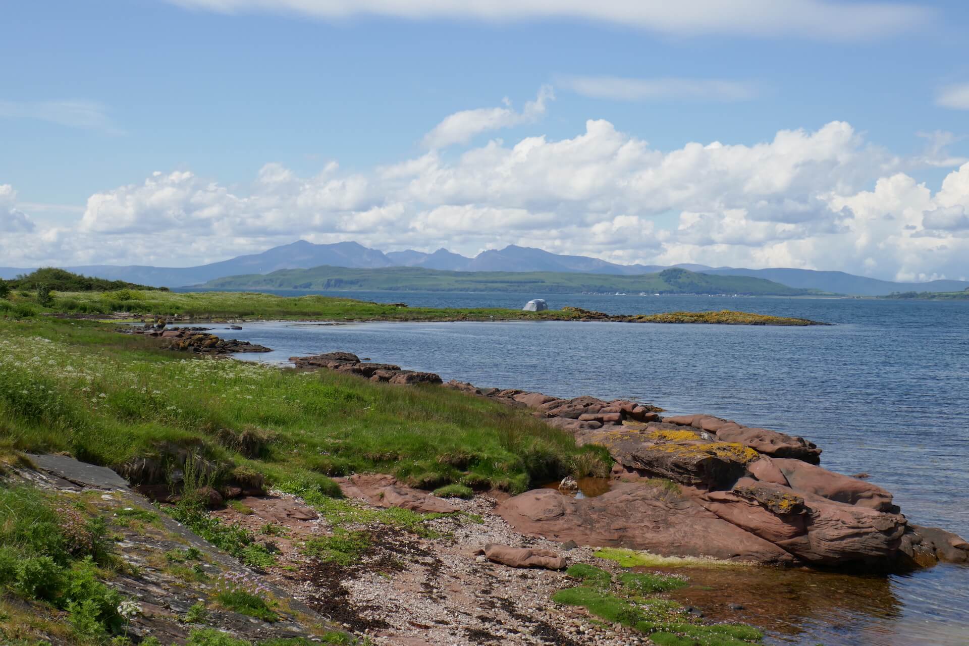 Sandstone coast of Isle of Cumbrae with Isle of Arran in the distance