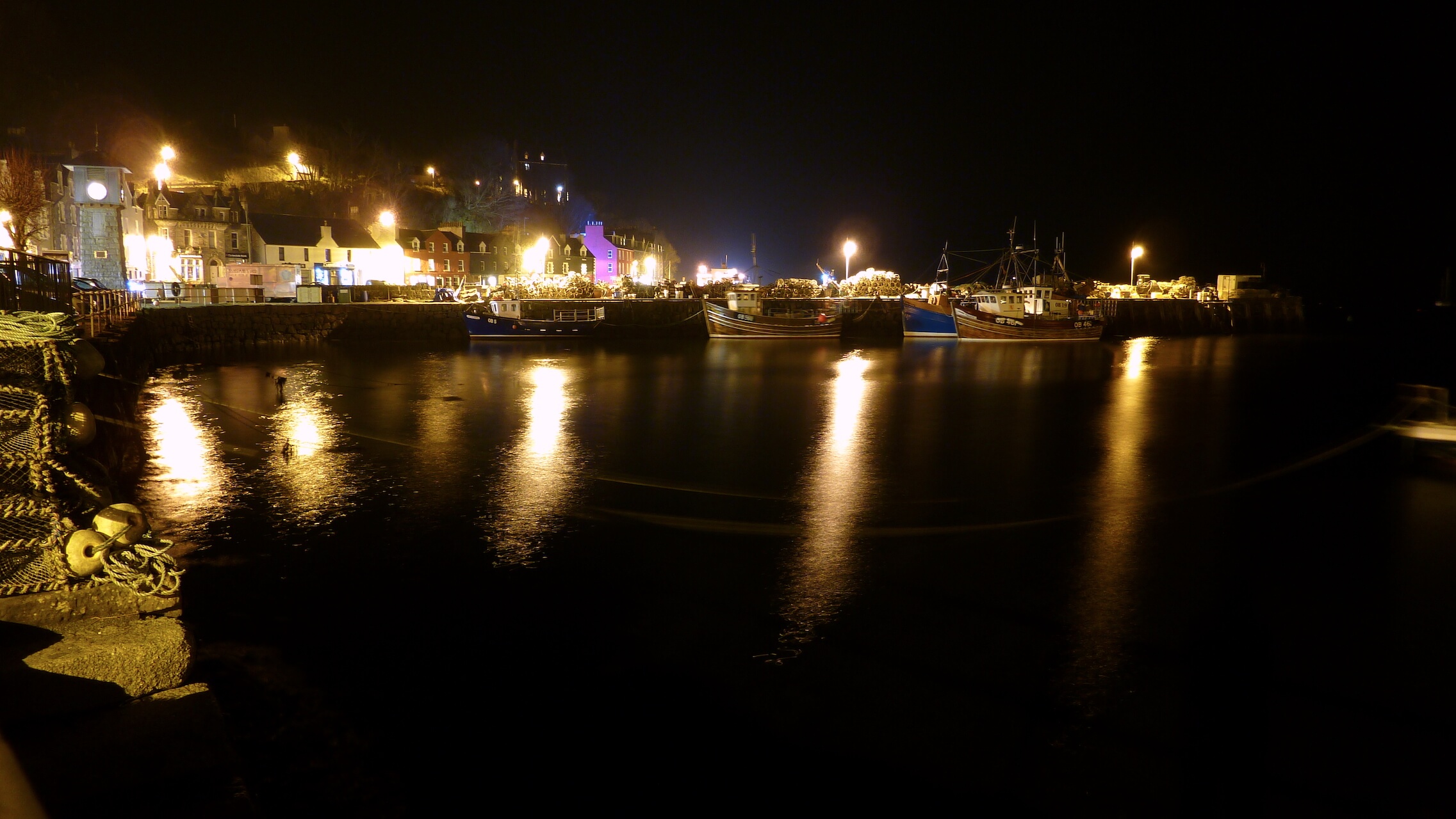 Tobermory Harbour lit up at night.