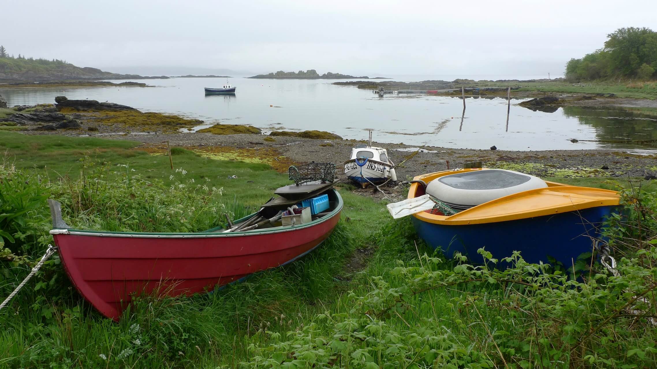 Small, colourful boats on the shoreline in Armadale, Sleat Peninsula, Skye